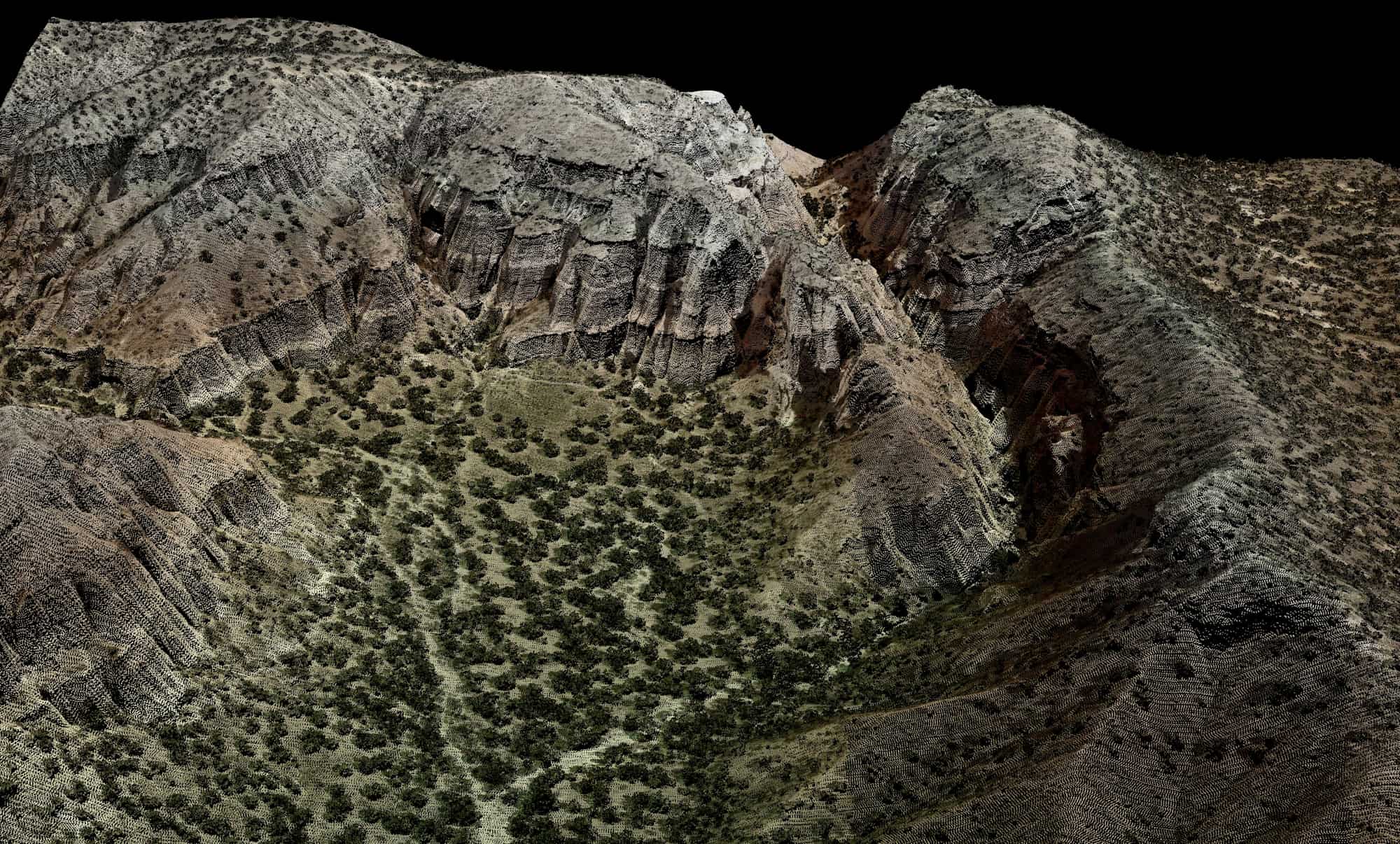 Colorized airborne LiDAR point cloud of desert cliffs, individual laser returns visible.